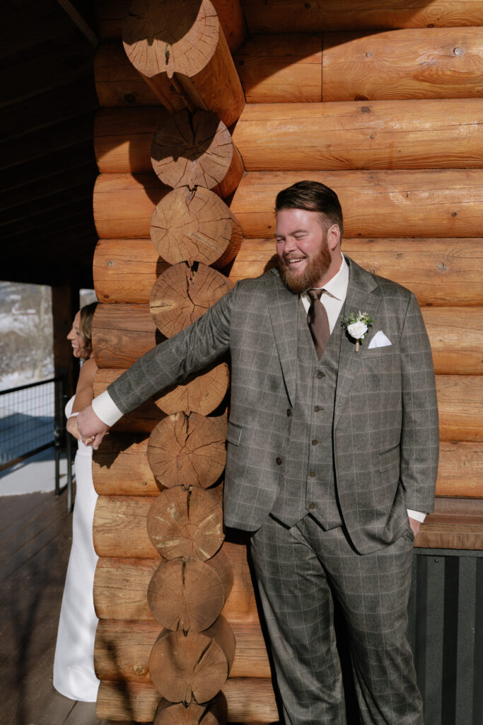 Elopement couple sharing a first look near a rustic log cabin in Grand Teton National Park Wyoming
