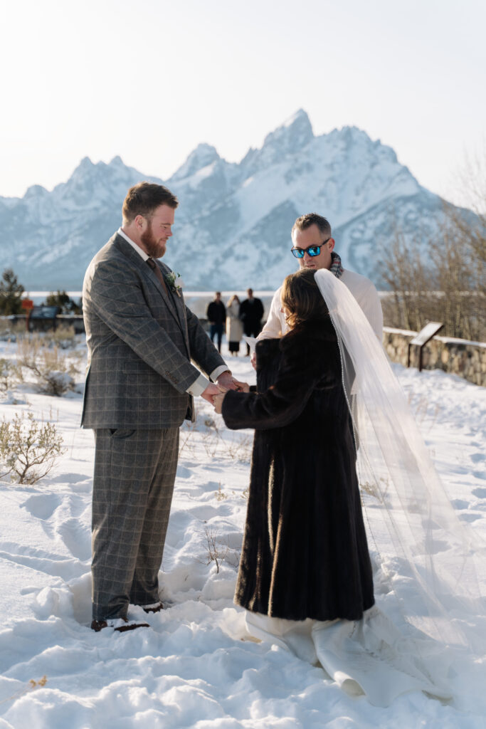 Couple exchanging vows during a winter elopement ceremony in Grand 