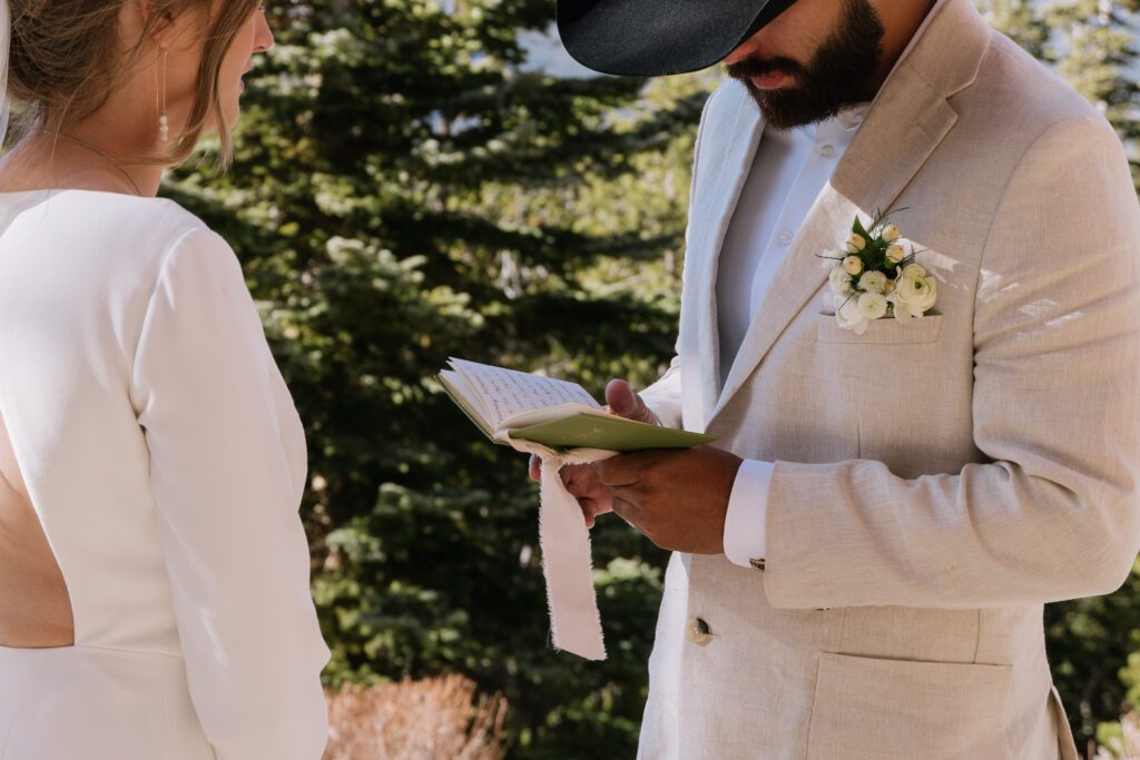 Groom reading vows during an intimate elopement ceremony in Rocky Mountain National Park surrounded by forest scenery