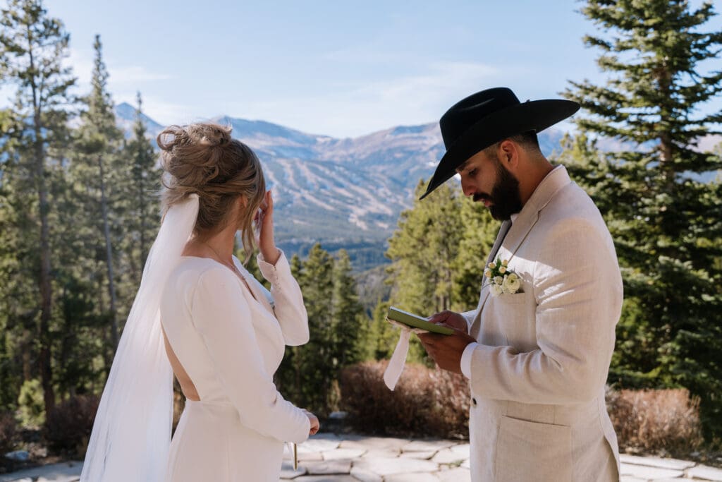 couple exchanging vows during an elopement in rocky mountain national park colorado with scenic mountain views and forest landscape