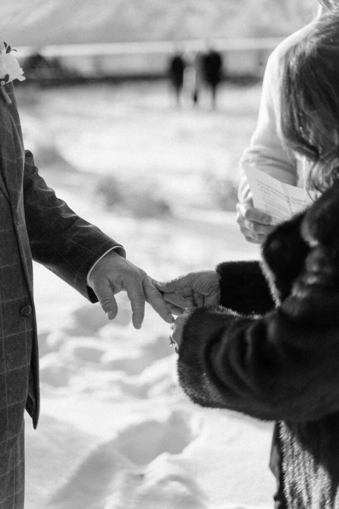 Close-up of couple exchanging rings during an intimate elopement at Snake River Overlook in Grand Teton National Park
