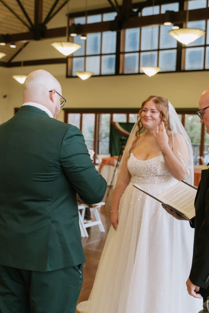 Bride and groom exchanging vows during a traditional indoor wedding ceremony with officiant
