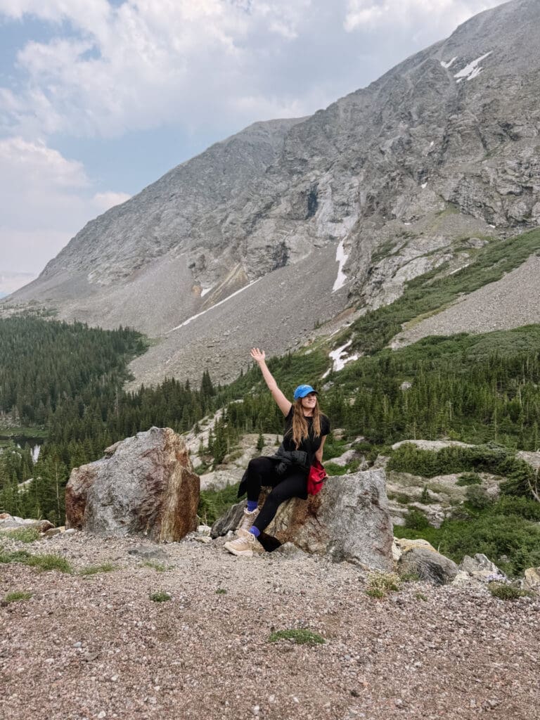 Makenzie Rose Davila exploring alpine trails in Glacier National Park as a destination elopement photographer surrounded by rugged mountain peaks, hiking trails, and breathtaking Montana wilderness